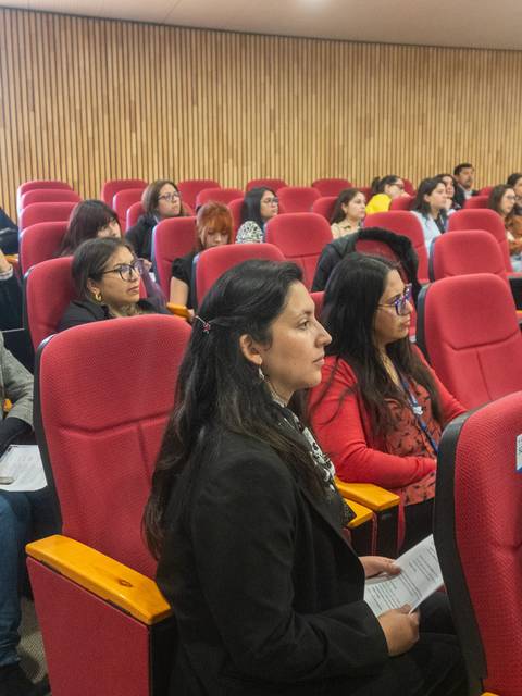 Una audiencia atenta en un salón de conferencias.