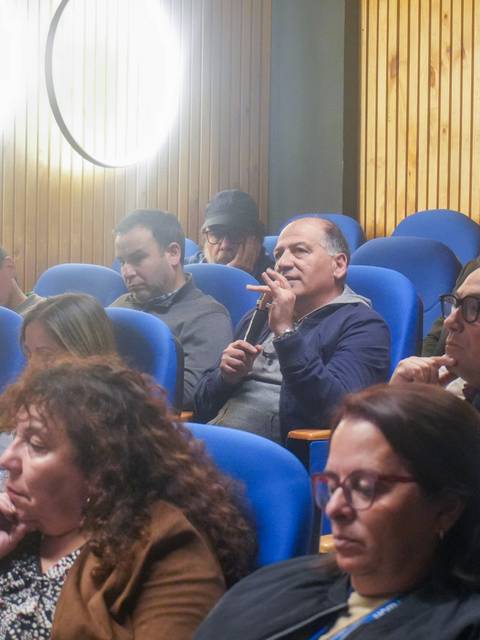Un grupo de personas sentadas en un auditorio prestando atención durante una charla.