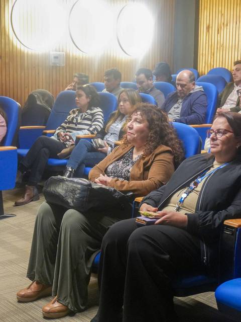 Un grupo de personas atentas en una sala de conferencia en Chile.
