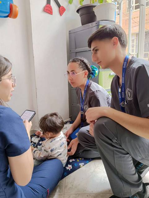 Un grupo de profesionales de la salud interactuando con un niño en un ambiente amigable.