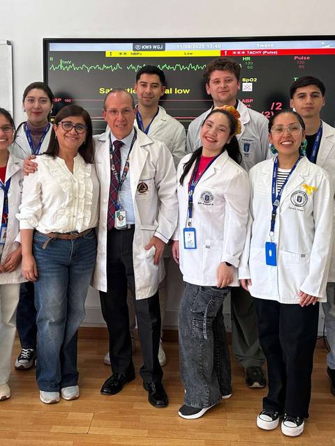 Un grupo de estudiantes de medicina posando juntos en un aula.