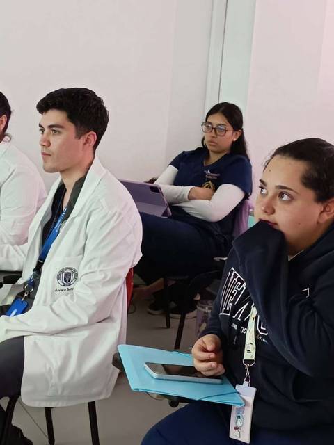 Un grupo de estudiantes en una clase, prestando atención al profesor.
