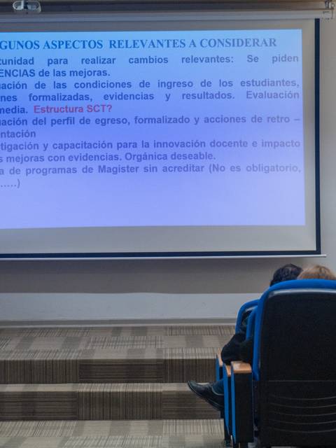 Un expositor presenta información en una conferencia sobre evaluación y oportunidades en la educación superior.