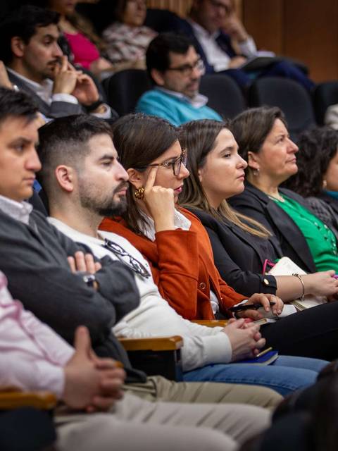 Una multitud atenta escucha una charla en un auditorio.