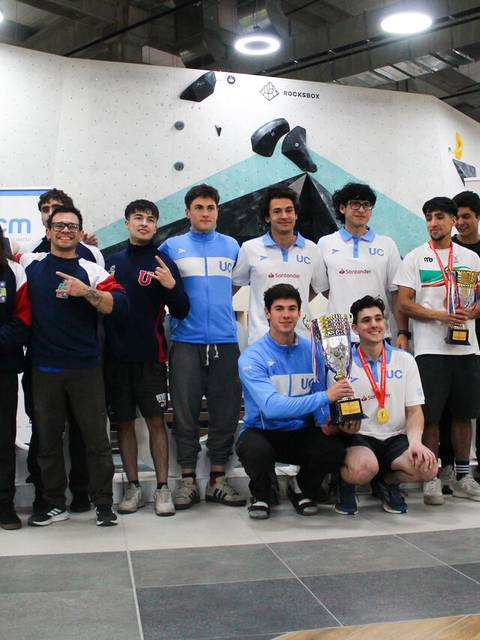 Un grupo de jóvenes escaladores posan felices con trofeos en una competencia.
