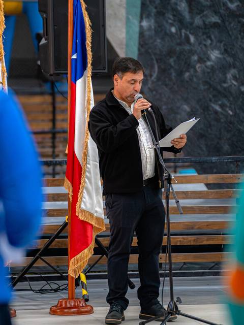 Un hombre dando un discurso frente a un grupo de personas en un evento.