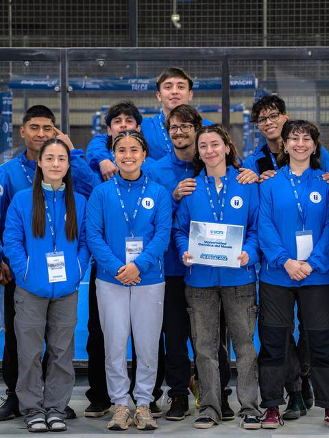 Un grupo de jóvenes con chaquetas azules posando juntos en un evento deportivo.