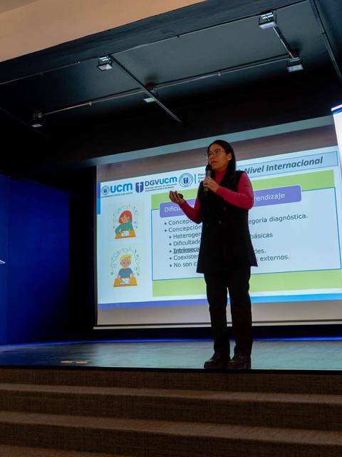 Una mujer presenta un tema sobre pedagogía en un seminario.