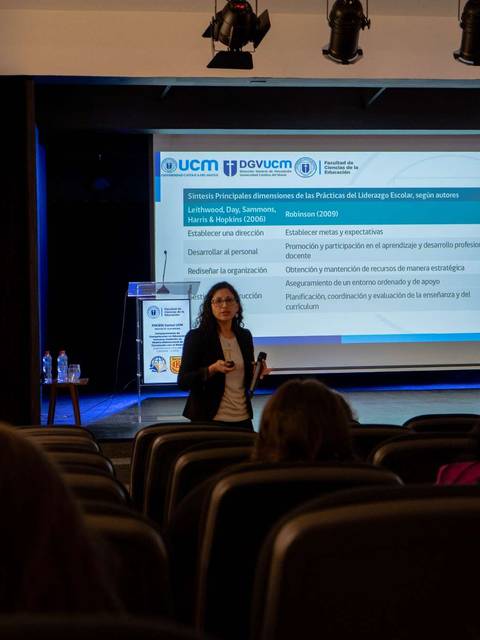 Una mujer presenta en una sala de conferencias ante una audiencia.