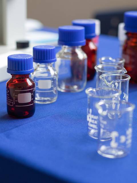 Mesa con frascos y tubos de ensayo listos para una actividad científica.