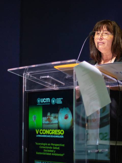 Una mujer está hablando en un congreso mientras está detrás de un atril.