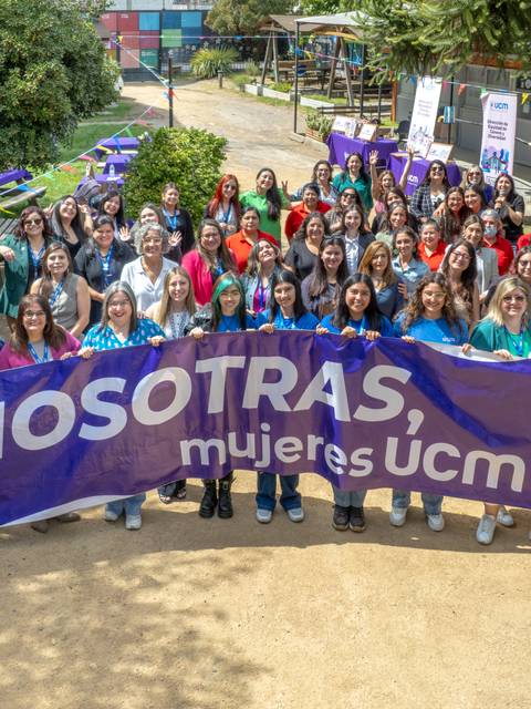 Celebración de mujeres de UCM con una gran bandera en un ambiente al aire libre.