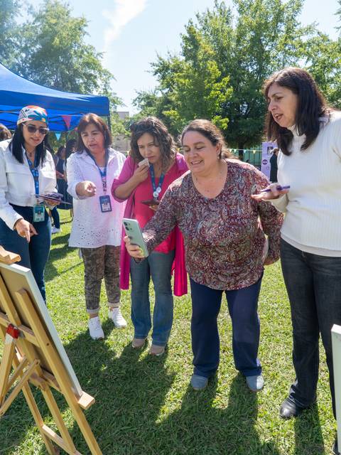 Un grupo de mujeres chilenas disfruta de una actividad al aire libre mientras miran obras de arte.