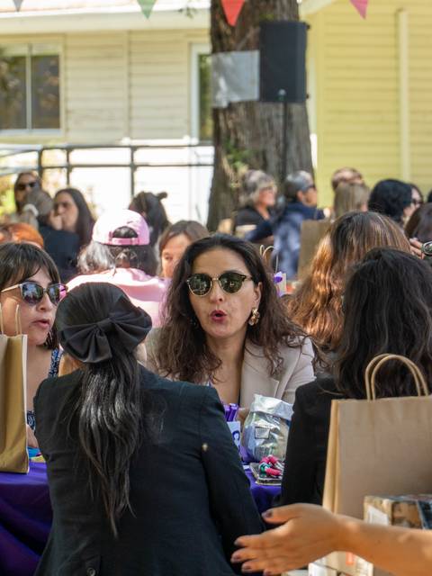Un grupo de mujeres conversando animadamente en un evento al aire libre.