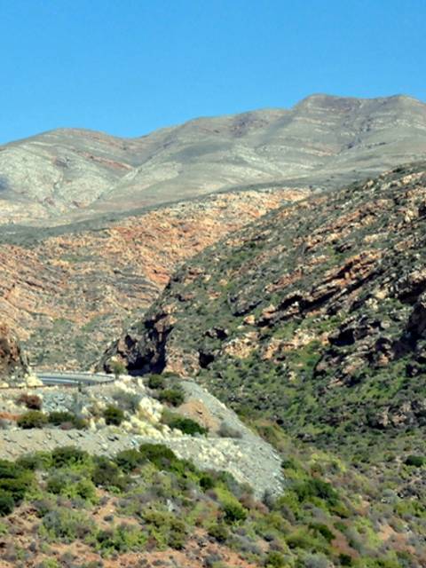Un paisaje montañoso con cerros y un cielo despejado.