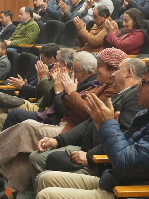 Un grupo de personas aplaudiendo en un auditorio en Chile.