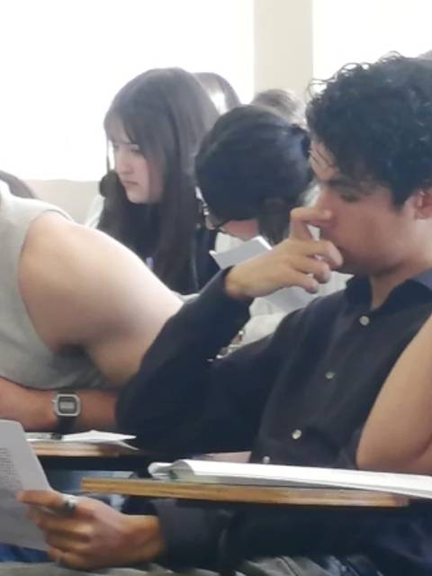 Estudiantes concentrados en un examen en un aula.