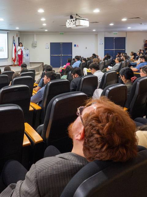 Una sala llena de estudiantes atentos a una presentación.