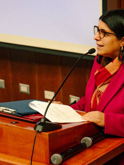 Una mujer habla en un auditorio mientras sostiene un discurso.