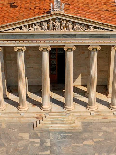 Imagen aérea de un edificio con columnas y tejados de tejas rojas, característico de la arquitectura clásica.