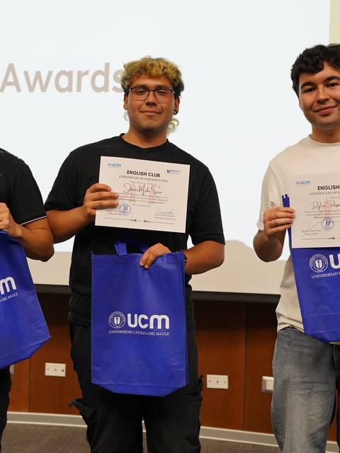 Tres jóvenes sosteniendo certificados de reconocimiento en un evento de premiación.