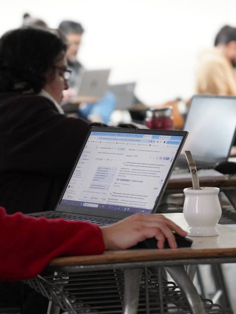 Un grupo de estudiantes utilizando laptops en una sala de clases.