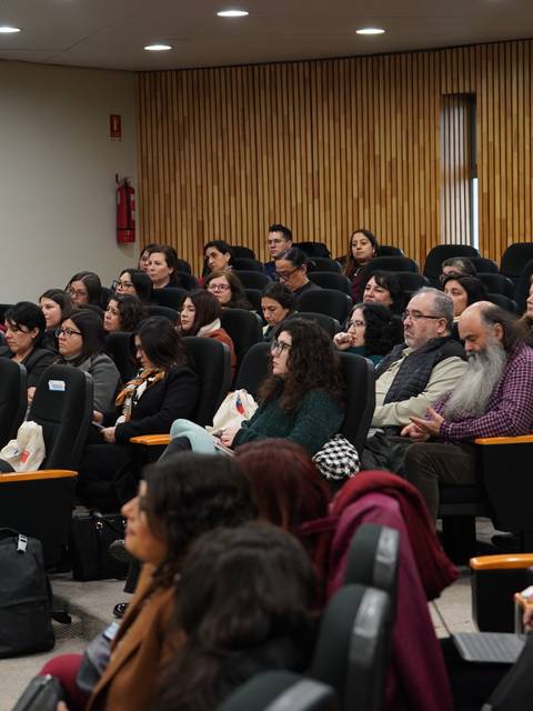 Un grupo de personas escucha atentamente en un auditorio durante una charla.