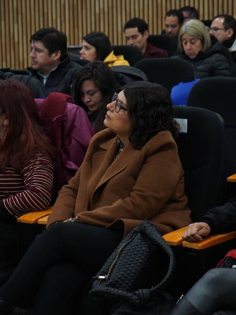 Un grupo de personas sentadas en un auditorio durante una presentación.