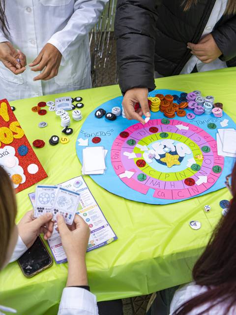 Un grupo de personas juega un juego de mesa al aire libre mientras disfrutan de un día soleado.
