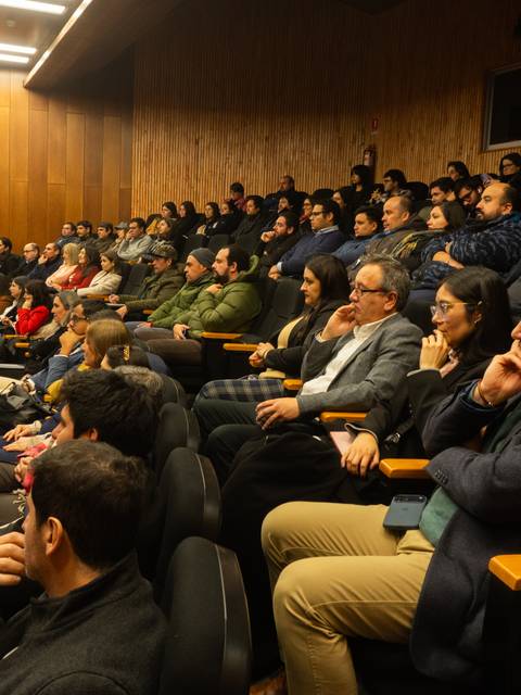 Una multitud de personas sentadas en un auditorio durante un evento.