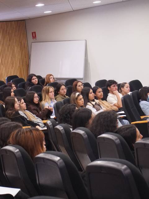 Un grupo de estudiantes escuchando atentamente en un aula.