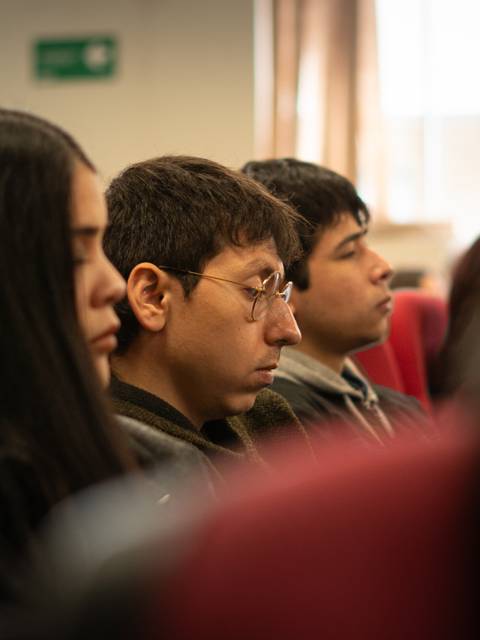 Un grupo de jóvenes escuchando atentamente en una charla.