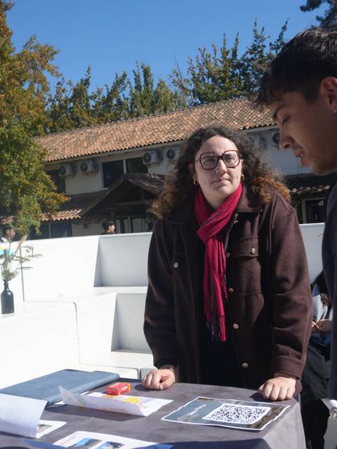 Una pareja de jóvenes conversando en una feria con un ambiente al aire libre.