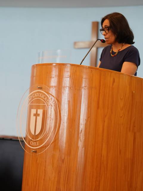 Una mujer está dando un discurso frente a un podio en un evento.