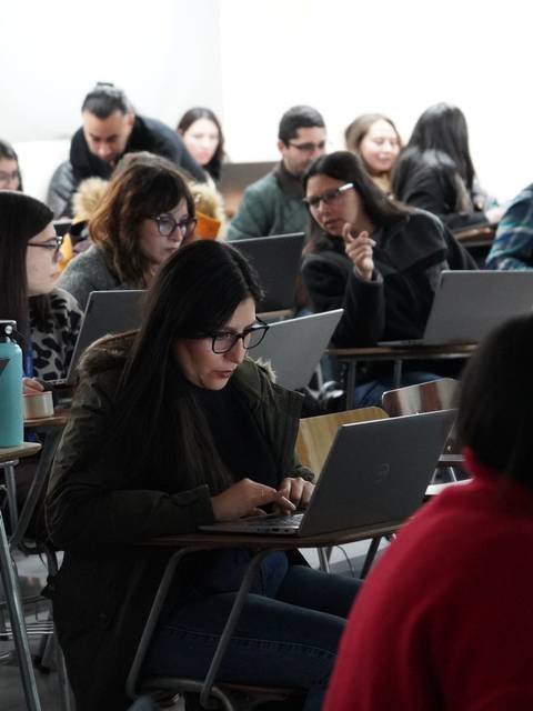 Un grupo de estudiantes trabajando en sus laptops durante una clase.