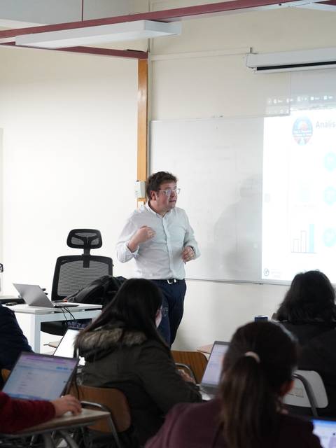 Un profe está explicando sobre inteligencia artificial mientras los alumnos lo escuchan atentamente.