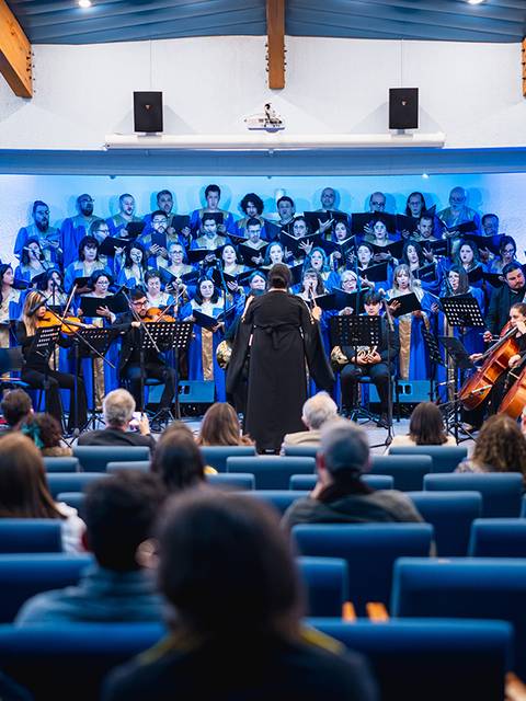 Un coro entusiasma al público con una presentación musical en un auditorio chileno.