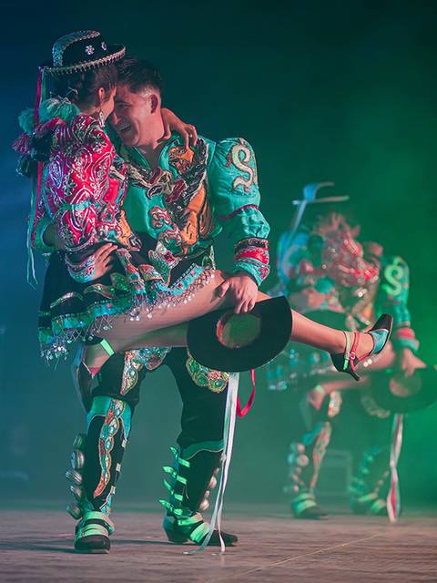 Un grupo de bailarines en trajes coloridos exhiben su arte en una presentación vibrante.
