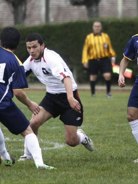 Un grupo de jugadores de fútbol compite en un partido en el campo.