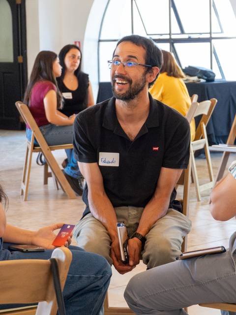 Tres personas conversando animadamente en un evento social.