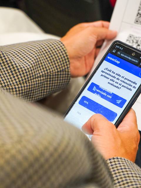 Una persona está usando un celular para escanear un código QR durante un evento.