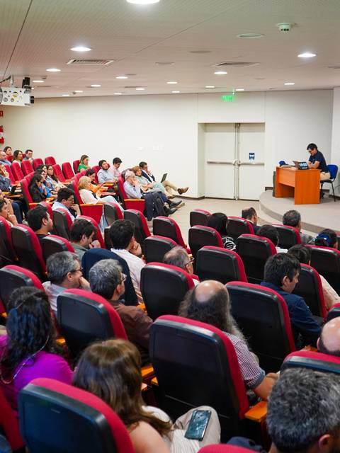 Una charla educativa en un auditorio lleno de público atento.