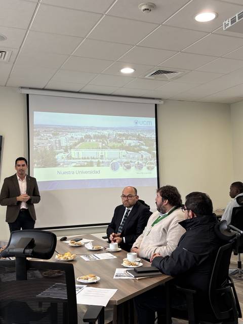 Una reunión en una oficina con un presentador frente a un grupo de personas.