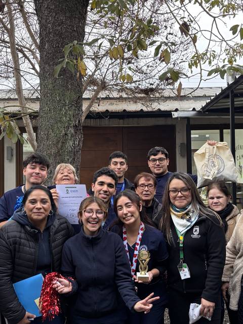 Un grupo de personas sonrientes celebra un logro en un encuentro comunitario.