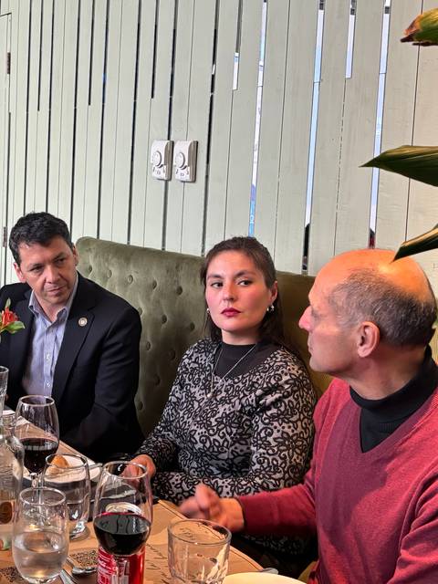 Un grupo de personas comparte una comida en un ambiente acogedor.