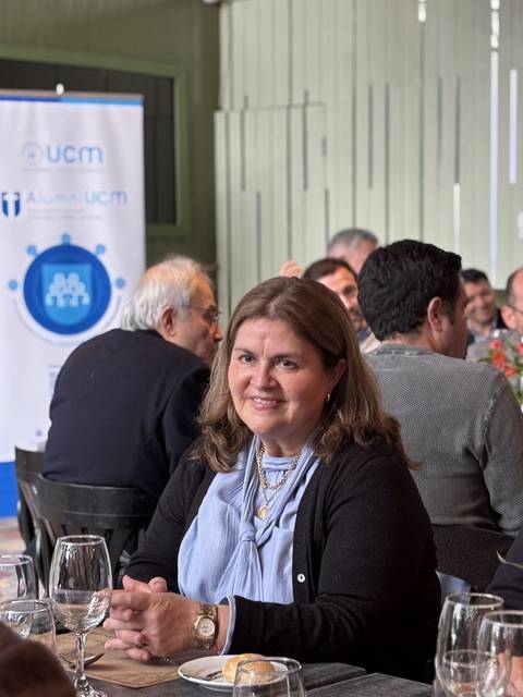 Una reunión social en un ambiente agradable con varias personas conversando y compartiendo en una mesa.