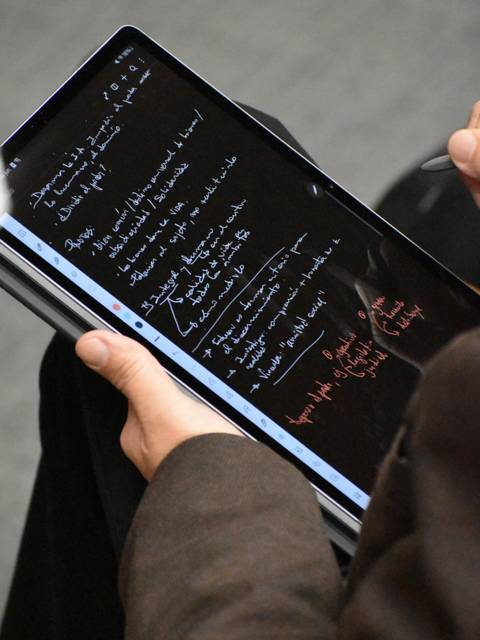 Una persona está tomando notas en una tablet con una pluma digital.