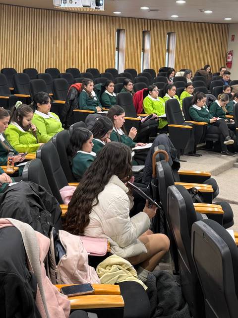 Una concurrida reunión de estudiantes sentados en un auditorio.
