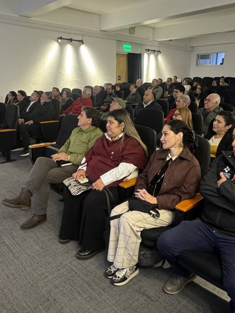 Un grupo de personas atentas en una sala de conferencia.