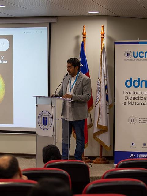Un expositor presenta en una conferencia sobre modelación y tecnología en educación matemática.